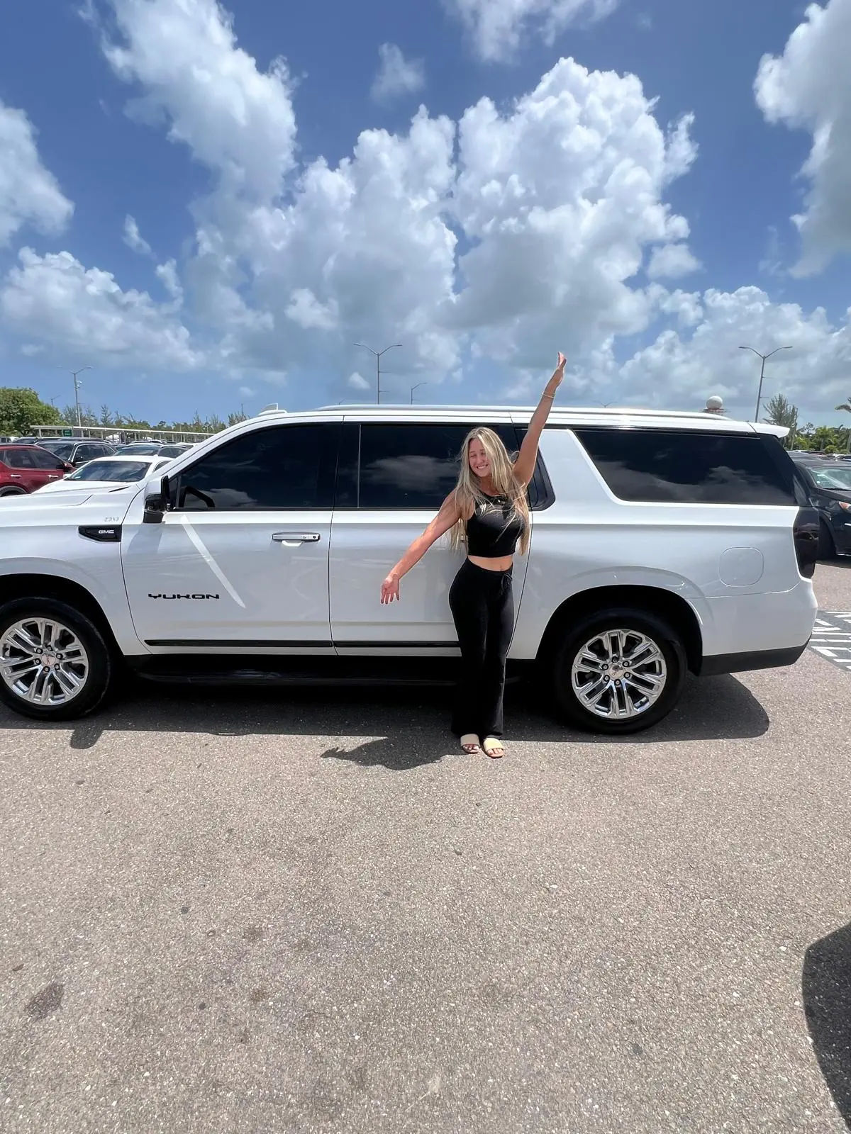 Guest beside a Quality Transportation vehicle at Nassau airport
